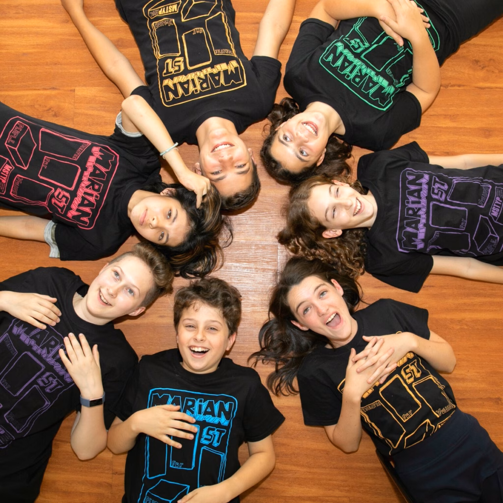 A group of young people wearing t - shirts lying on the floor.