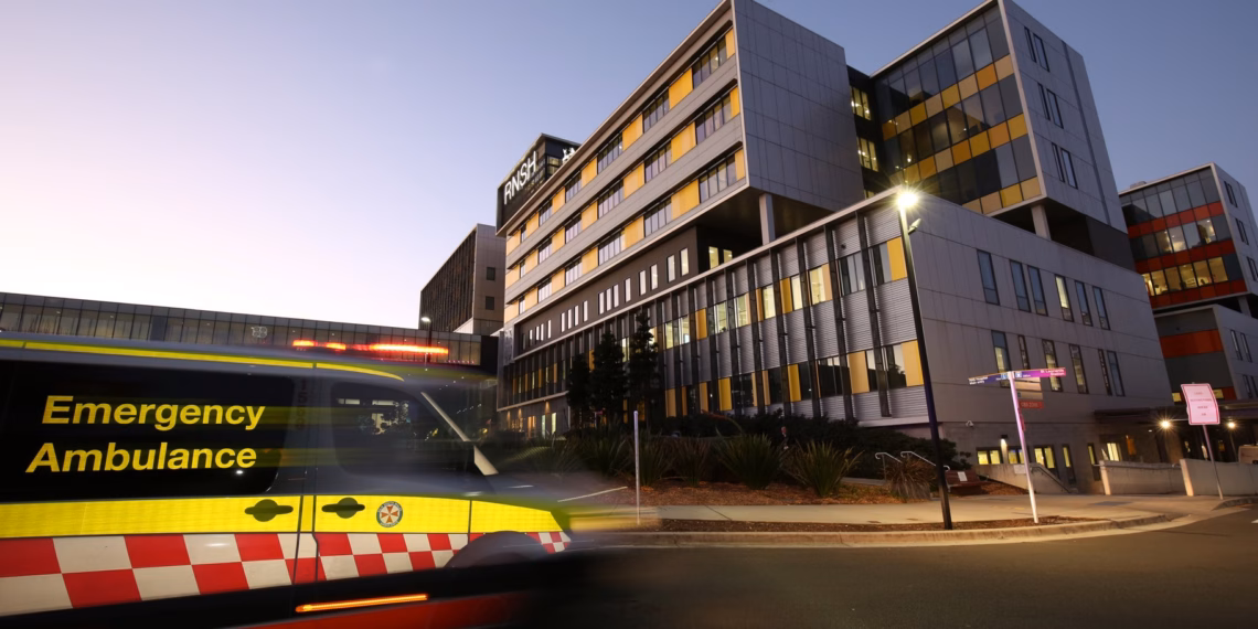 A ambulance is driving past a large building.