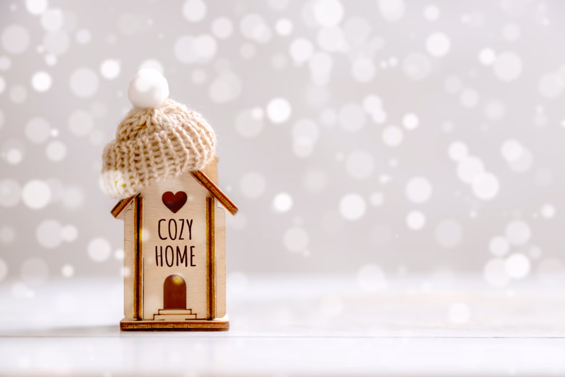 A cozy home with a cozy home sign on a wooden house with snow.
