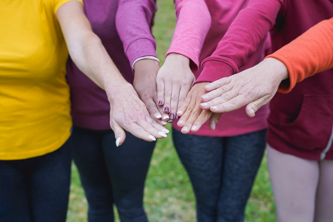 Group of women holding hands together.