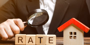 Man looking at rate on wooden blocks with magnifying glass.