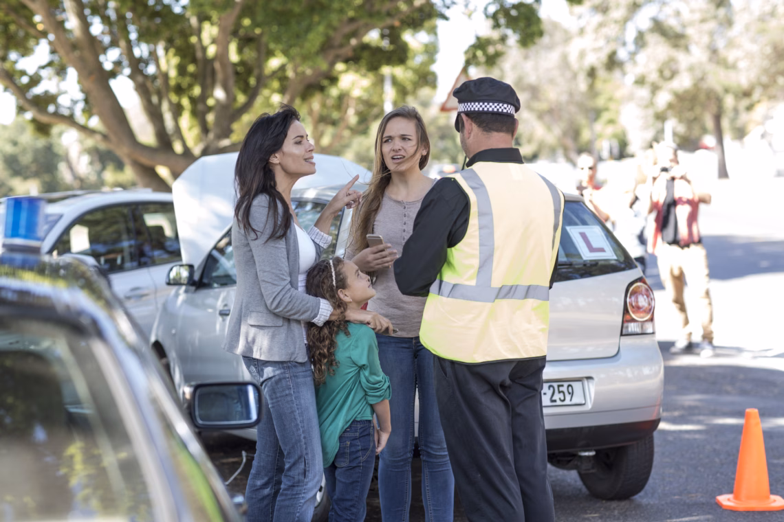 People and policeman at car accident scene