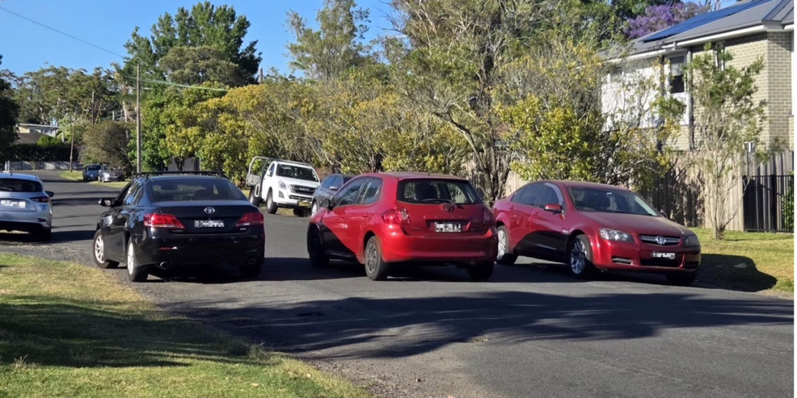 A view of a residential street in Berowra with cars parked on the side, representing the traffic concerns regarding the proposed narrowing of Anembo Road.